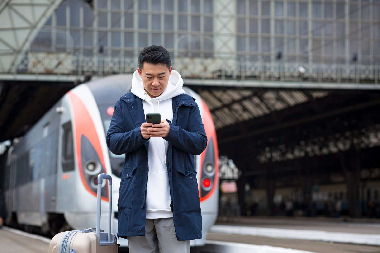 Asian tourist booking accommodation at home using mobile phone